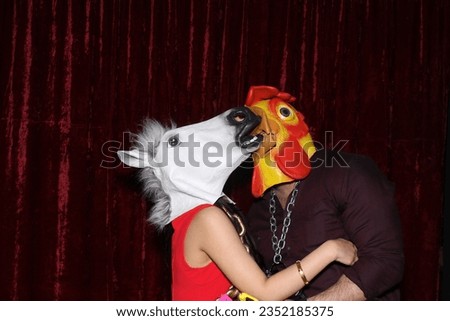 Photo Booth. Unidentifiable People wear Horse and Chicken Head Masks and pose and play while their pictures are taken in a Photo Booth. Party Photo Booth. Wedding Photo Booth. Horsing Around. Funny. 
