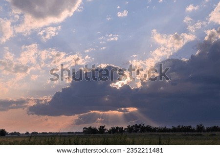 the sky with the rays of the sun through the clouds over the field