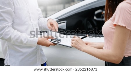 Automotive business, car sale or rental concept Customer with car dealer agent making deal and signing on agreement document contract in auto showroom or on street