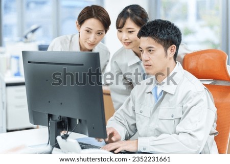 young asian engineers using computer together in office