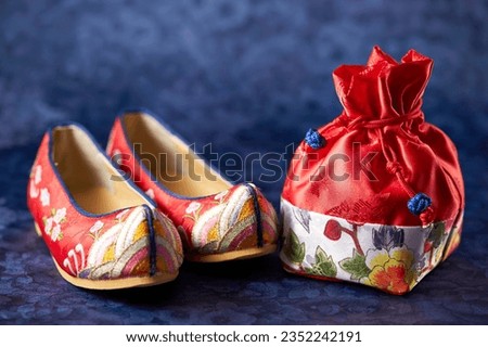 Traditional shoes and gifts on Korean script background Royalty-Free Stock Photo #2352242191