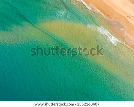 Summer sea nature background,Aerial view of Waves crashing on sandy shore,Sea surface ocean waves background