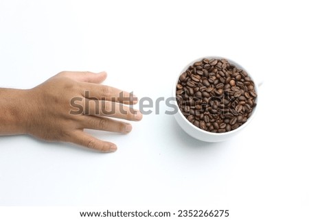 fresh coffee bean in transparent tray, with big mug with white background 