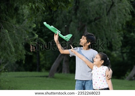 Asian kids boy and girl flying airplane in the park. happy indian family kid concept. Lifestyle theme concepts. Royalty-Free Stock Photo #2352268023