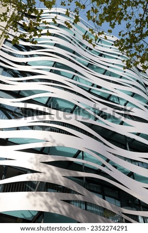 Windows of a modern avant-garde building, made of metallic materials and curvilinear shapes.