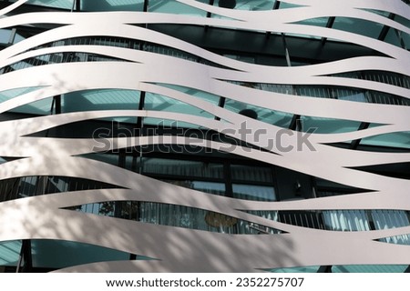 Windows of a modern avant-garde building, made of metallic materials and curvilinear shapes.