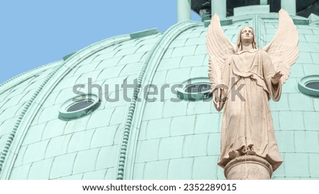Banner with statue of winged angel at Evangelical church Saint Nikolai at sunset with copy space for text and blue sky background, Potsdam, Germany.