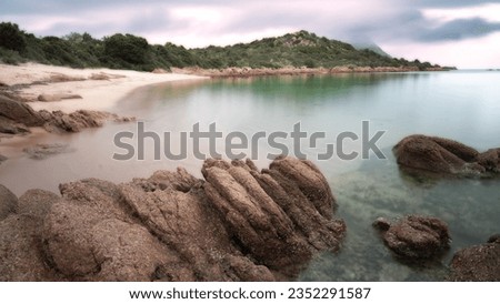 Landscape photo of Cala Tuccia, nestled in the Costa Dorata of Loiri Porto San Paolo in Sardinia. The clouds and the uncertain weather make the winter landscape gloomy but of a unique tranquility