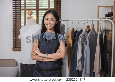 portrait of a young woman who owns an online clothing business stand with arms crossed and smile.