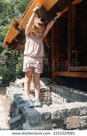 A pretty girl playing by the well. Photo taken in the Czech Republic, 2023