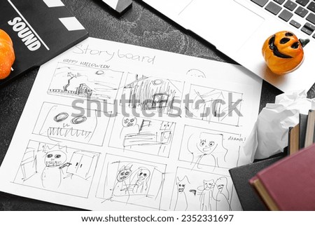 Laptop with storyboard and pumpkins on grunge grey background. Halloween celebration