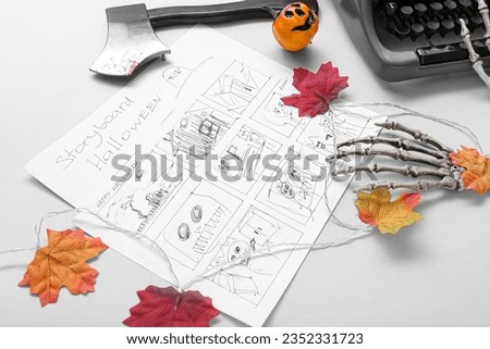 Typewriter with storyboard and Halloween decor on grey background