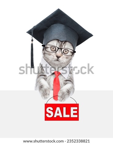 Cute graduated cat wearing eyeglasses and necktie looks above empty white banner and  holds signboard with labeled "sale". isolated on white background