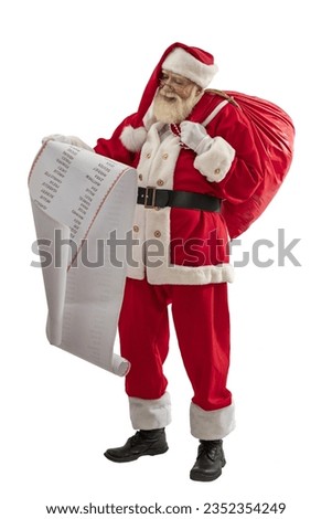 Santa Claus on white background isolated. Senior male actor old man with a real white beard in the role of Father Christmas holding a bag of gifts and a list of names