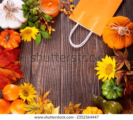 Autumn wooden background frame with pumpkins, sunflowers, candle and paper bag. Fall harvest season concept. Copy space, top view, mockup