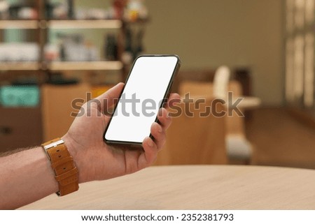 Man using smartphone in cafe, closeup. Space for text