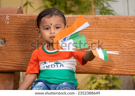 Little boy wearing Tricolor Tshirt of India.Holding and waving Indian flag, Happy Independence day and Republic day of India concept photo