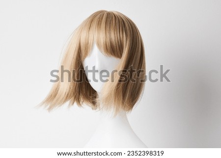 Natural looking blonde fair wig on white mannequin head. Short hair cut on the plastic wig holder isolated on white background, front view
 Royalty-Free Stock Photo #2352398319