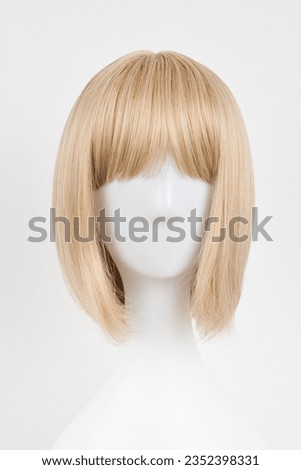 Natural looking blonde fair wig on white mannequin head. Short hair cut on the plastic wig holder isolated on white background, front view
 Royalty-Free Stock Photo #2352398331