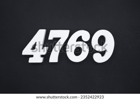 Black for the background. The number 4769 is made of white painted wood.