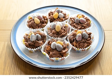 Easter cookies in paper baskets with colored eggs are placed on a white plate, close-up