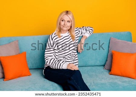Photo of pretty lovely lady sitting couch look aside dreaming new furniture isolated bright color background