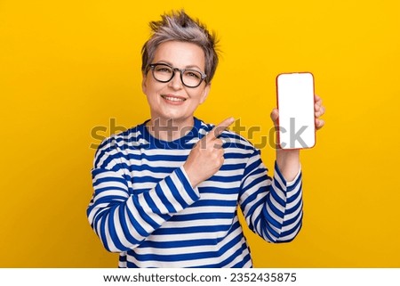 Photo of pensioner smiling woman white hair promoter directing smartphone touch screen web menu shop isolated on yellow color background