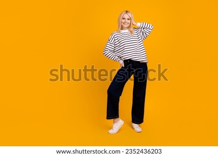 Full size photo of pretty lovely nice senior lady try fit new clothes posing standing isolated bright color background