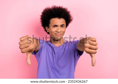 Photo of dissatisfied disappointed gloomy guy wear trendy purple clothes two hands thumbs down bad choice isolated on pink color background