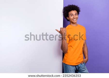 Portrait of positive guy youngster indicating finger empty space billboard cheap price product place isolated on purple color background