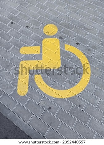 yellow sign on the pavement disabled parking 