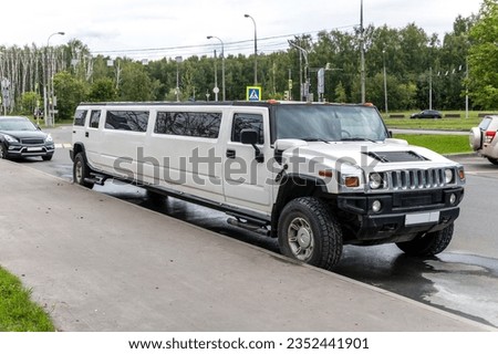There is a long white car on the road Royalty-Free Stock Photo #2352441901