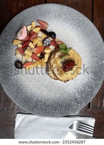Delicious pancakes with mixing fruits on plate.