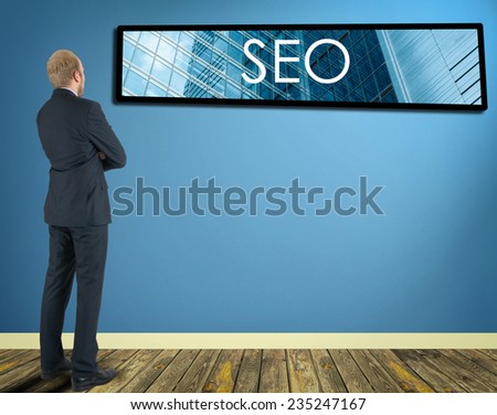 businessman in a room looking at a wall of which is the frame with inscription SEO