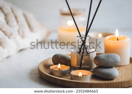 Cozy corner for home meditation and relaxation. Aroma diffuser, burning candles, stones for comfort, pleasure, aromatherapy. Decor for apartment, house, indoors design. Domestic spa concept