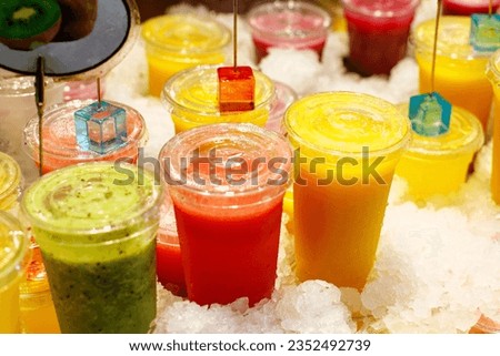 bright fruit smoothies in cups on the market close-up. kiwi smoothie, watermelon smoothie, mango smoothie. drinks to go