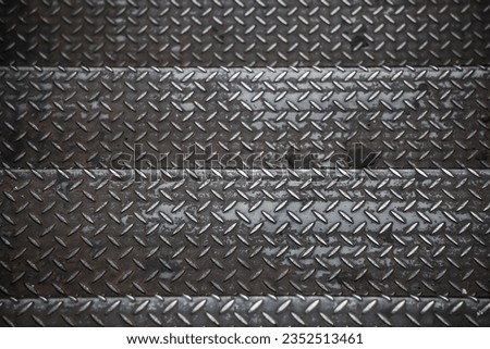 Old rusty black diamond metal plate background, grunge texture of dark metallic sheet with repetitive diagonal oval shape pattern, embossed steel surface protect slipping for stair or ramp floor