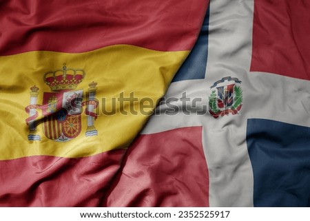 big waving national colorful flag of spain and national flag of dominican republic . macro