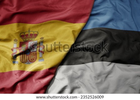 big waving national colorful flag of spain and national flag of estonia . macro