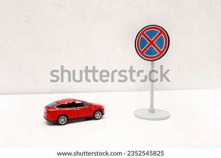 toy red car in front of a road sign no stopping with copy space.