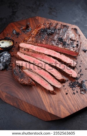 Traditional barbecue wagyu gourmet flank steak with charred onions served as close-up on a modern design wooden board Royalty-Free Stock Photo #2352563605