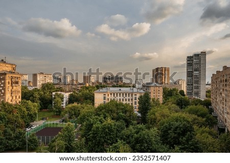 Residential area of the city with residential buildings, a school building, a courtyard and a sports ground among green trees. Royalty-Free Stock Photo #2352571407