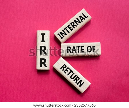 IRR - Internal Rate of Return symbol. Concept word IRR on wooden cubes. Beautiful red background. Business and IRR concept. Copy space.