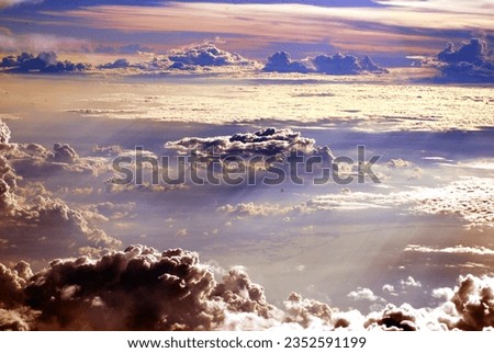 cloudscape at sunrise from the window of an airplane flying over indonesia