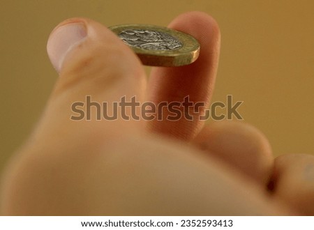 A photo of a white boy's hand holding a coin. 