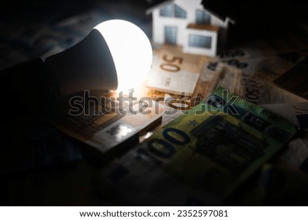 Electricity bill next to a calculator, a bulb and money. Electricity price concept Royalty-Free Stock Photo #2352597081