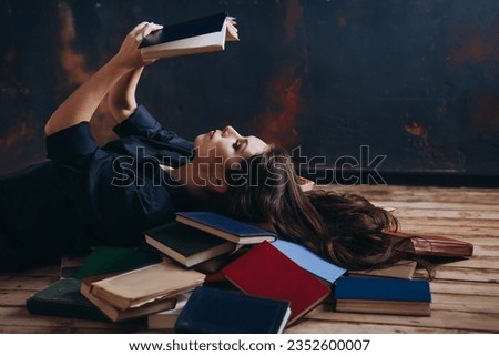 A relaxed woman underlie and reads in a room full of books.