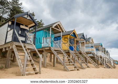Beach huts at Wells next the Sea on the North Norfolk coast pictured above the golden sandy beach on wooden stilts to protect them from high tides.