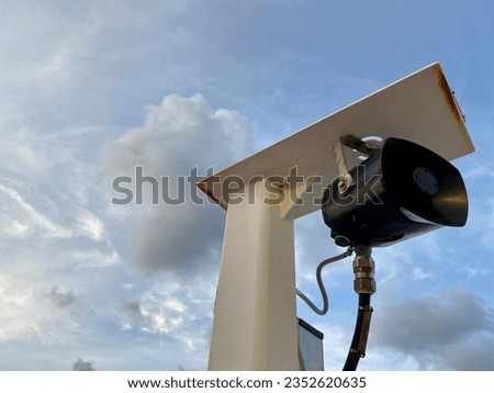 Pole mounted speaker with cloudy sky background 