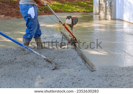 Utilizing tamping machine to align compacted concrete on new driveways Royalty-Free Stock Photo #2352630283